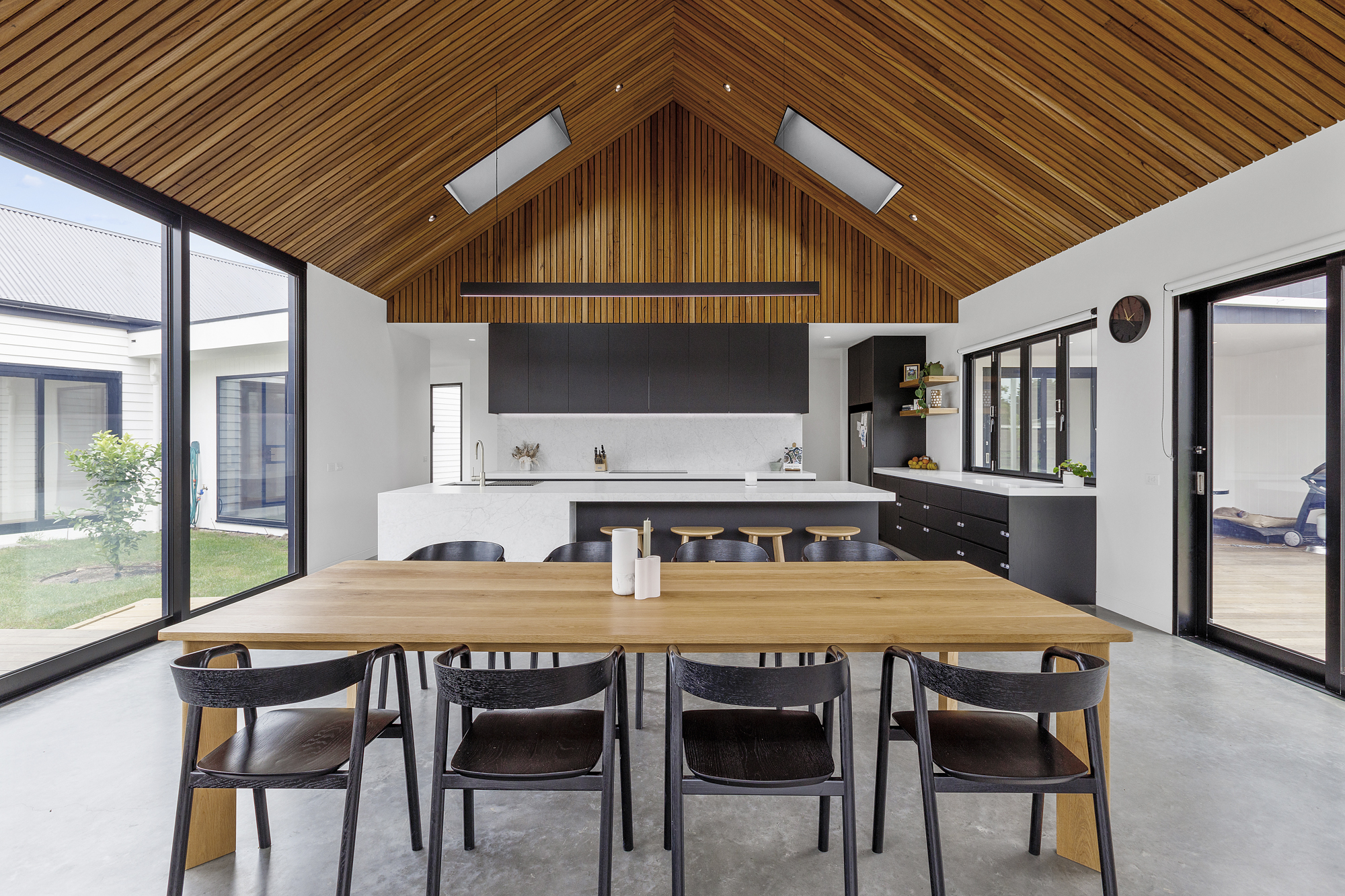 A cathedral timber ceiling creating a visual point in this kitchen/dining area with lots of natural light flooding through.