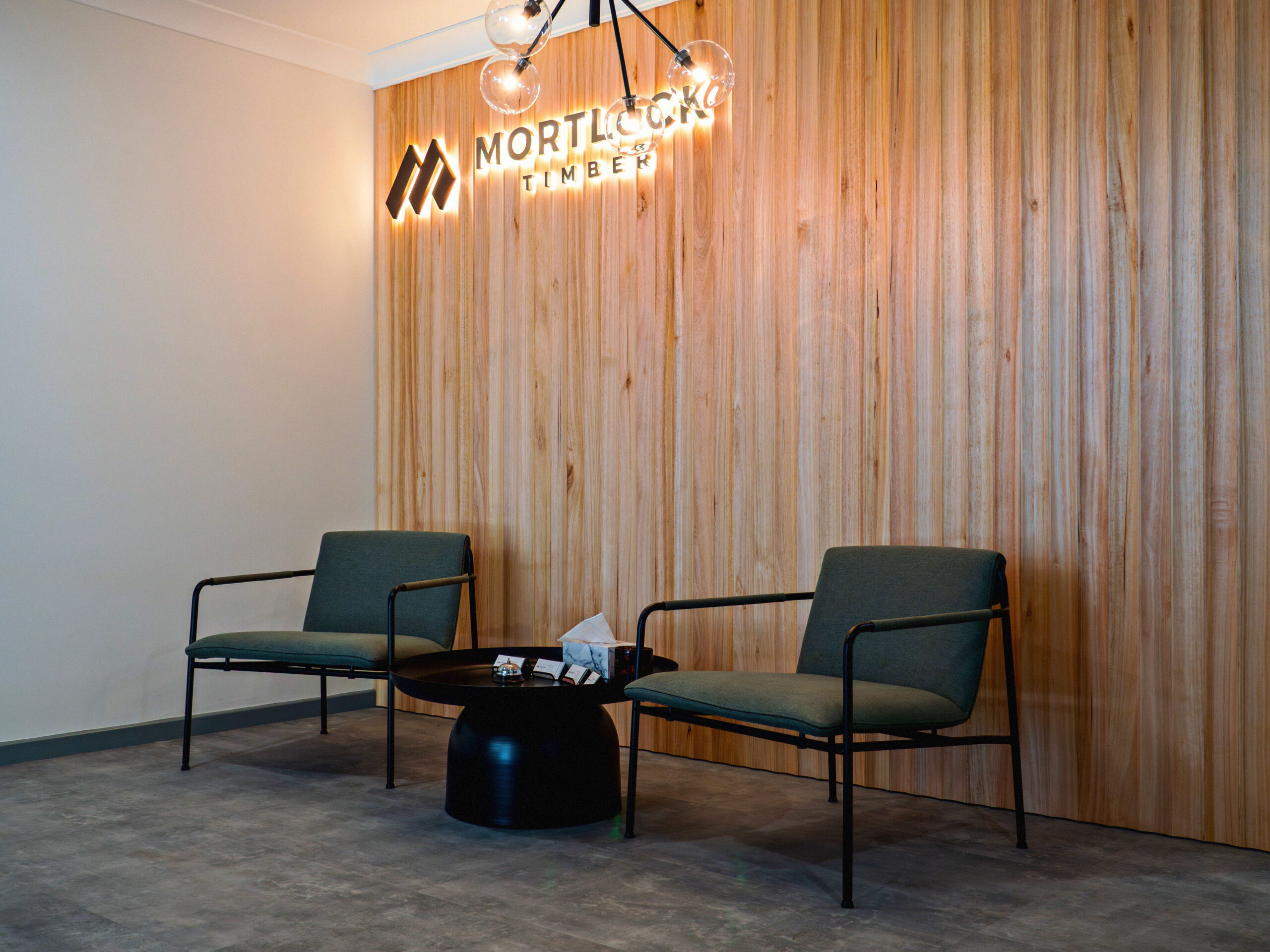 Interior of Mortlock Timber building showing two chairs and a coffee table in front of 30x30 Proplank American Oak feature wall