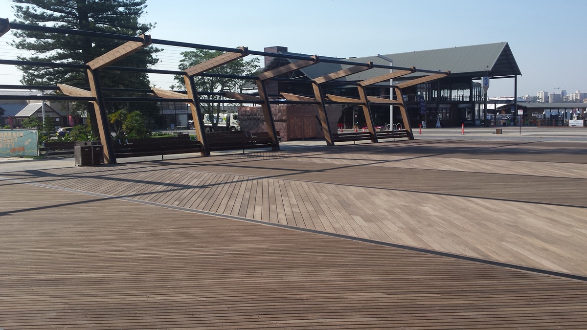 Timber cladding on the Freshwater project showing natural weathering in progress, with warm and silvered tones developing unevenly across boards at different stages of exposure.