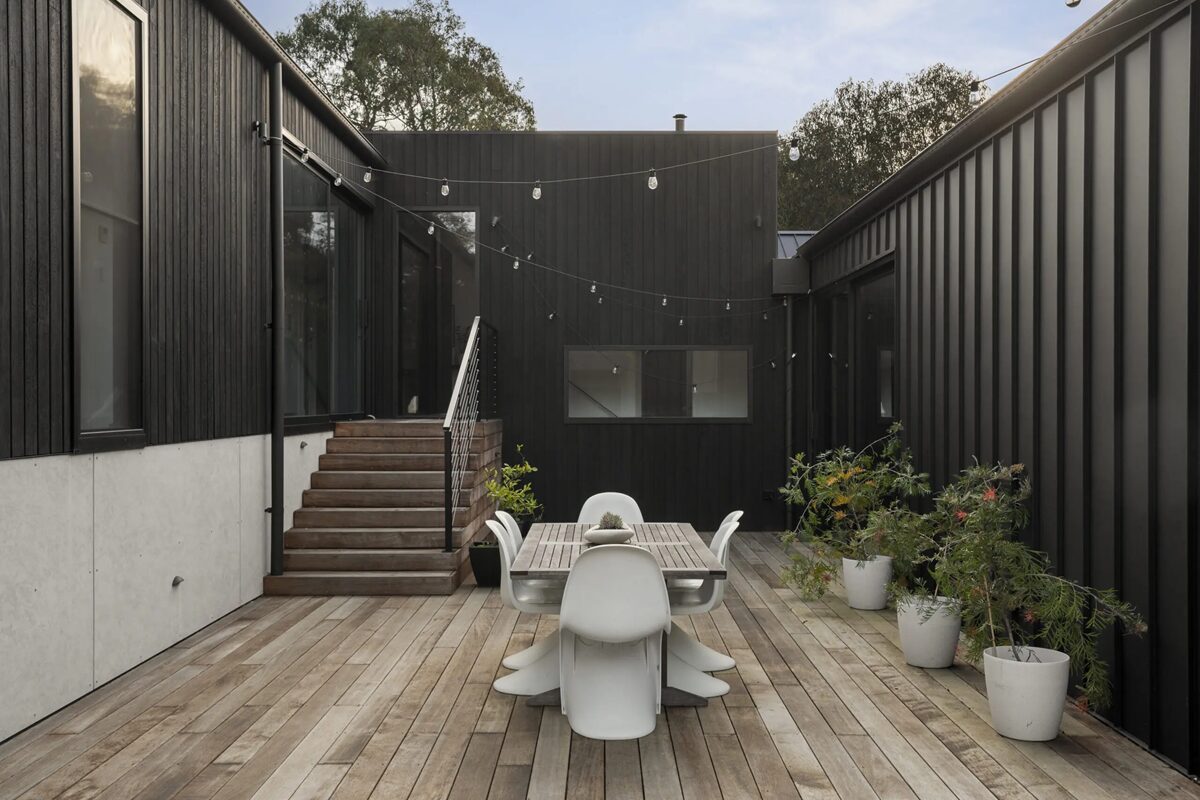 Naturally weathered timber decking in a contemporary residential courtyard, developing a soft silver-grey patina over time.