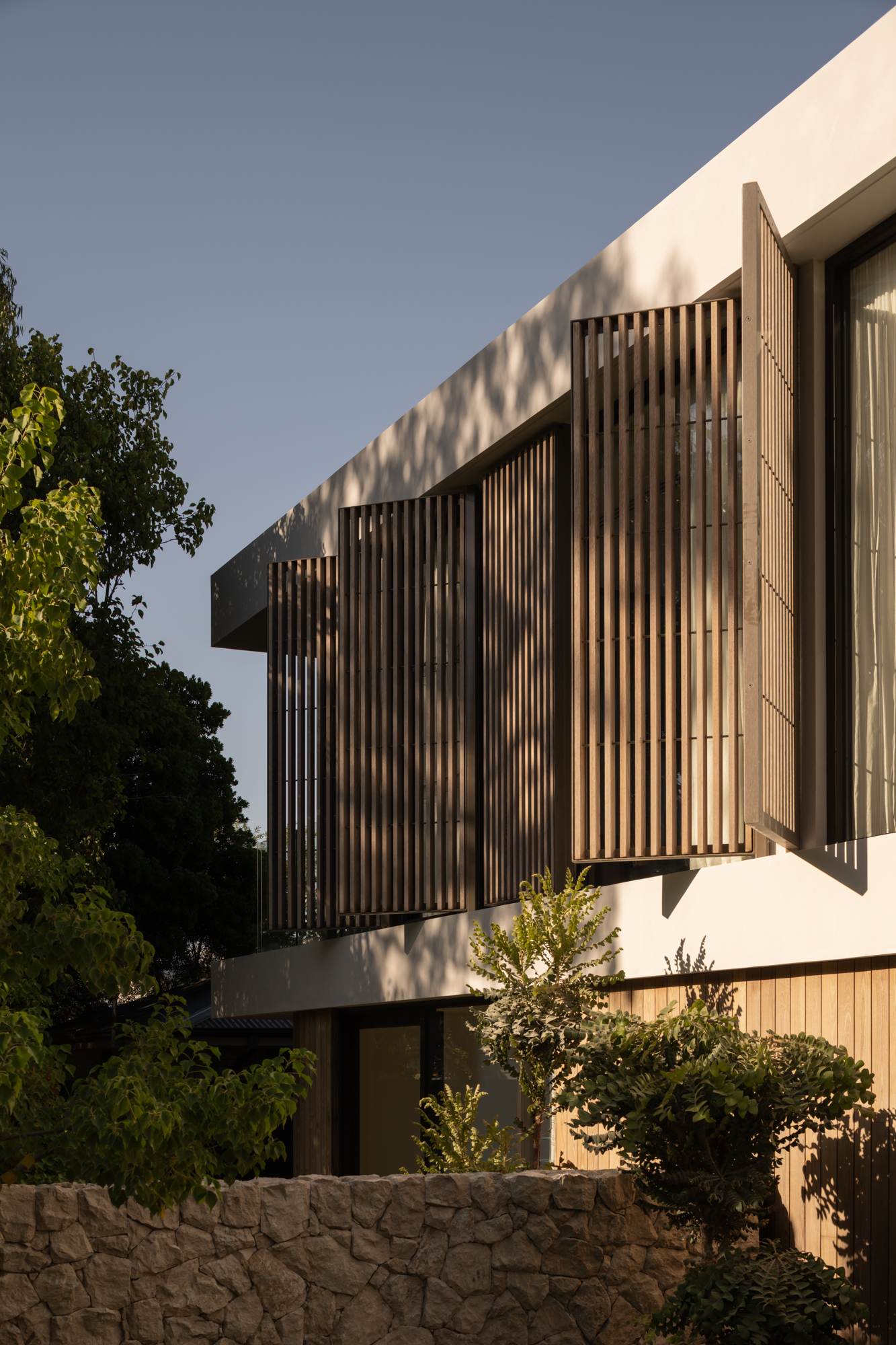Contemporary Cottesloe residence featuring Burnt Ash timber cladding and vertical timber screening across the upper-level façade, with rendered walls, glazing and landscaped gardens.