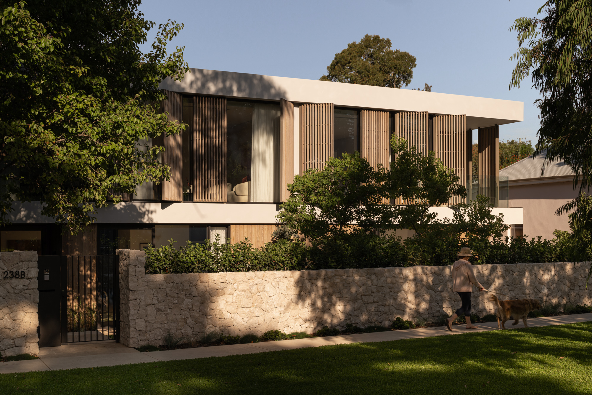 Burnt Ash TRENDPLANK timber cladding and vertical timber detailing across the exterior of The Patina House in Cottesloe, contrasting with white rendered walls and natural stone landscaping.