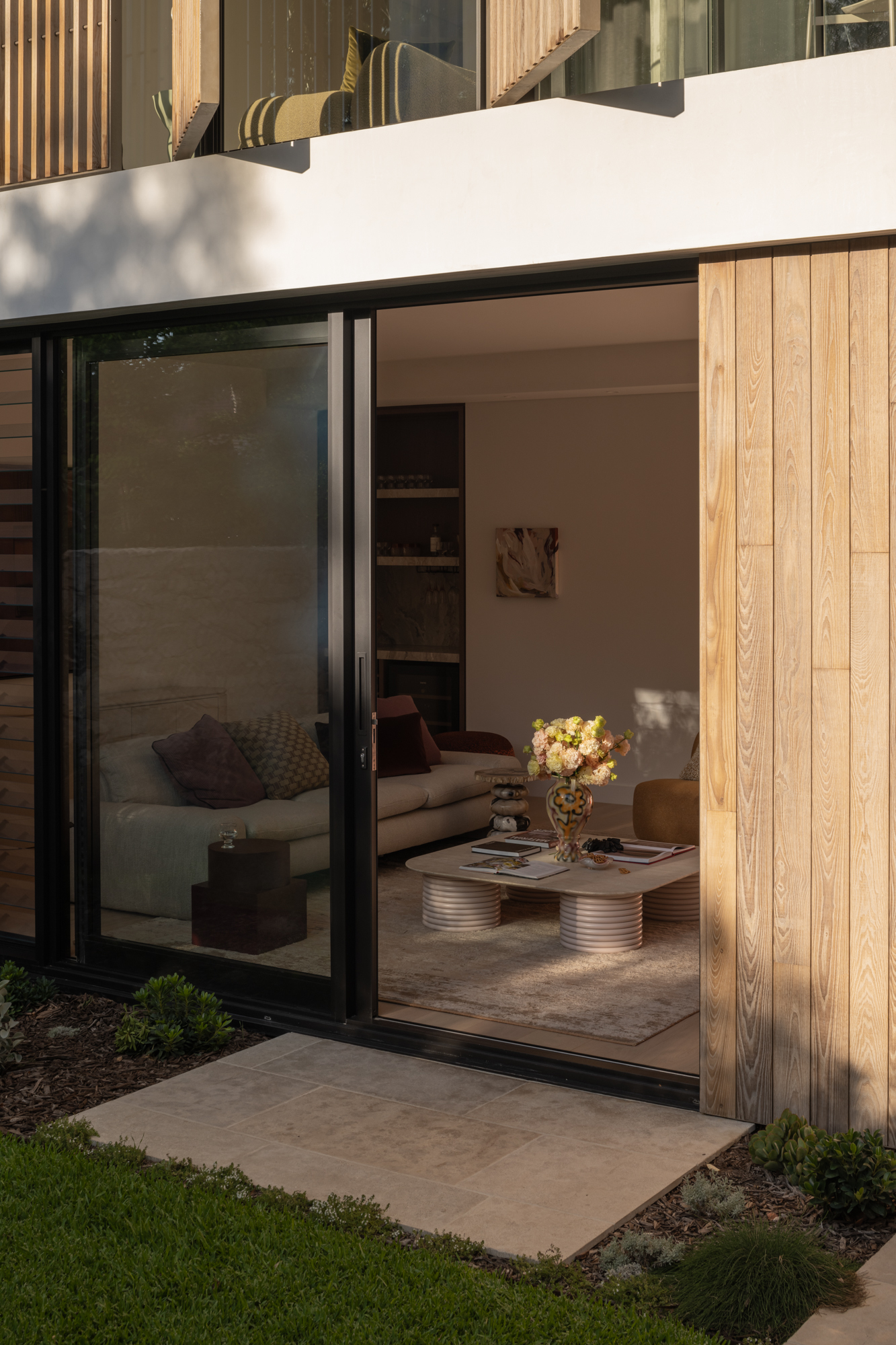 Close view of Burnt Ash TRENDPLANK timber cladding and vertical timber elements framing large glazed openings at The Patina House in Cottesloe.